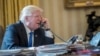 President Donald Trump speaks on the phone with Russian President Vladimir Putin, Jan. 28, 2017, in the Oval Office at the White House in Washington. 