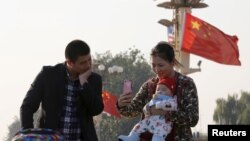 一对中国父母在北京天安门拍照留念。（2015年11月2日）