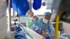 Personal médico atiende a un paciente con COVID-19 en la unidad de cuidados intensivos del Hospital Universitario de Estrasburgo, Francia, el 13 de enero de 2022.