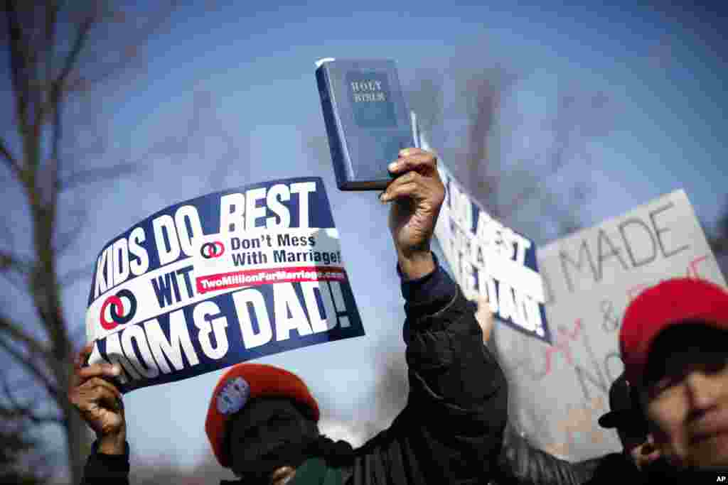 A demonstrator holds a bible while marching outside the Supreme Court in Washington as the court heard arguments on California&#39;s Proposition 8, March 26, 2013. 