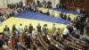 Opposition deputies cover their seats with gigantic national flags to protest against a draft law on languages, which was scheduled to be discussed during a session in the Ukrainian parliament in Kiev