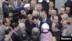 Syria's President Bashar al-Assad (C) chats with people after prayers for Eid al-Adha at al-Afram Mosque, Damascus, Syria, October 26, 2012.