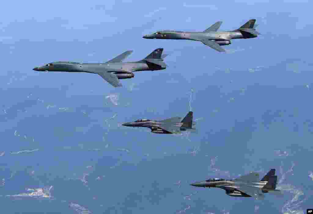 韩国国防部发布的照片显示，美国空军B-1B轰炸机（上面两架）和韩国F-15K战斗机在韩国上空飞行（2017年6月20日）。