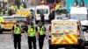 Representantes de las fuerzas de seguridad recorren la escena del crimen, una céntrica calle de la ciudad de Glasgow, Escocia.