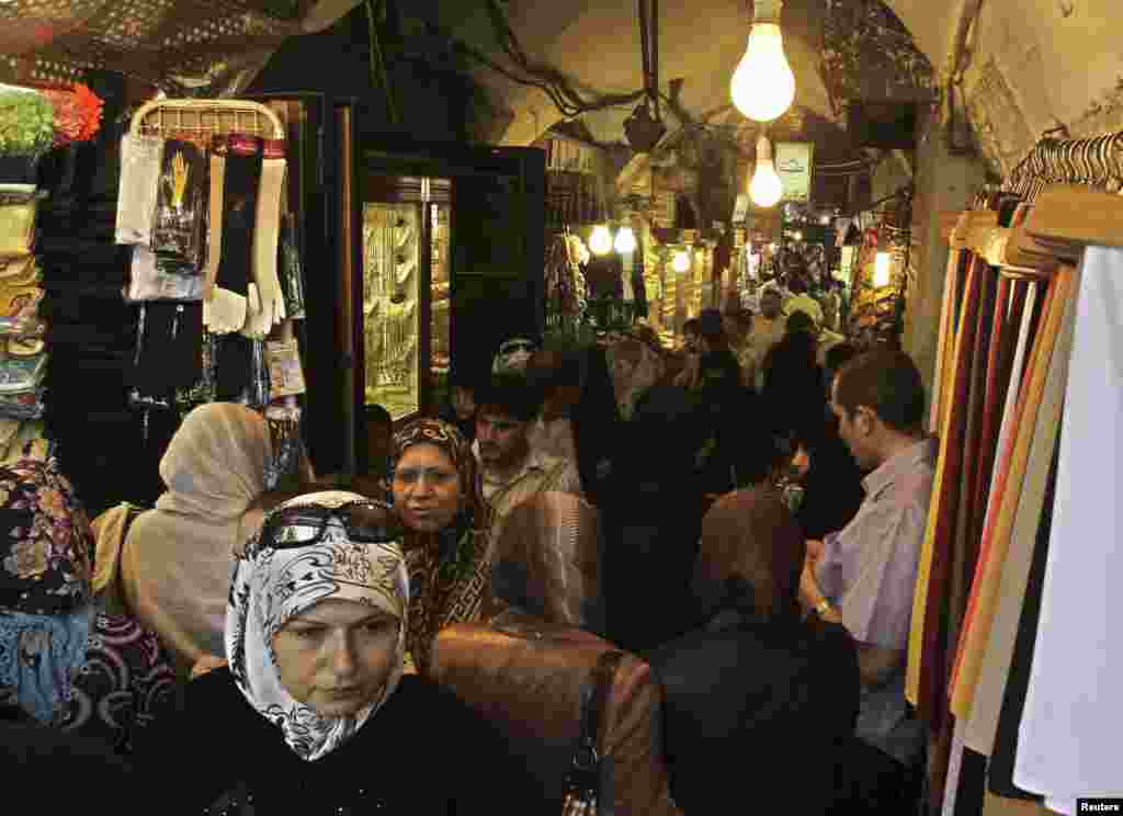 People shop at the main market, or souk, in the Syrian city of Aleppo, June 23, 2010.