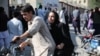 A woman arrives on a motorbike to search for a relative at a hospital in Kabul on Sept. 30, 2022, after a blast in a learning center in the Dasht-e-Barchi area of Afghanistan's capital.