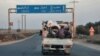 Syrians escape with their belongings north of Azaz in the country's northern Aleppo governorate, Oct. 17, 2022, as locals and others from the opposition-held cities of Azaz, Jarabulus, Mari, and al-Bab try to flee a Hay'at Tahrir al-Sham (HTS) jihadist group's advance.