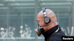 A man wearing a mask is seen on a street in Beijing May 2, 2013. Street-level anger over air pollution that blanketed many northern cities this winter spilled over into online appeals for Beijing to clean water supplies, especially after rotting corpses