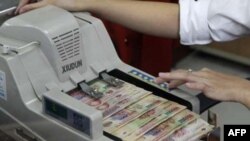 Trong 14 tháng qua, chính phủ Việt Nam đã phá giá tiền đồng 3 lần vì nguồn vốn nước ngoài không đủ để bù cho khoản nhập siêu