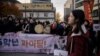 15일 서울에서 수험생이 수능 시험장에 들어가고 있는 가운데, 후배 학생들이 시험장 앞에서 응원구호를 외치고 있다. 