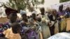 Women wait to receive baby food in the village of Koleram, southern Niger, during the launch of a UN-backed blanket feeding operation aimed at fighting malnutrition among children under the age of two, 28 Apr 2010
