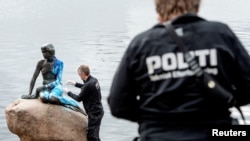 Oficiales de policía inspeccionan la estatua de La Sirenita, cubierta de pintura en lo que las autoridades locales dicen que es un acto de vandalismo, en Copenhague, Dinamarca, (Archivo)