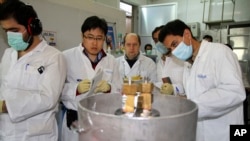 IAEA 관계자들과 이란 기술자들이 20일 이란 테헤란 남쪽 나탄즈 핵 시설에서 고농축 우라늄 생산용 원심분리기 작동을 중단시키고 있다.