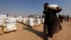 A displaced woman, who fled from Mosul due to Islamic State violence, carries food in Khazer refugee camp, east of Mosul, Iraq, Nov. 7, 2016. 