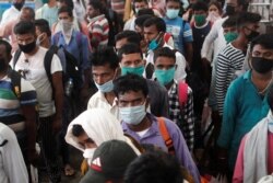 Migrantes que regresan de sus ciudades natales esperan en fila para hacerse la prueba de COVID-19, durante una campaña de prueba rápida de antígenos en una estación de tren en las afueras de Mumbai, India, el 3 de octubre de 2020.