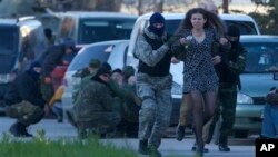 Anggota milisi pro-Rusia mengevakuasi penduduk setempat ketika pasukan Rusia menyerbu pangkalan udara Belbek, di luar Sevastopol, Krimea.