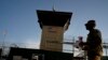 FILE - A task force member walks past the Camp 6 detention facility at the Guantanamo Bay U.S. Naval Base, Cuba, in this June 5, 2018 photo, reviewed by U.S. military officials. 