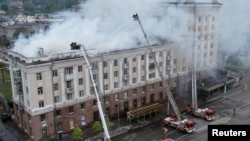 Пожежники працюють біля житлового будинку, який постраждав від російського ракетного удару у Дніпрі, 19 квітня 2024 року. Фото: Пресслужба ГУ ДСНС України у Дніпропетровській області/REUTERS
