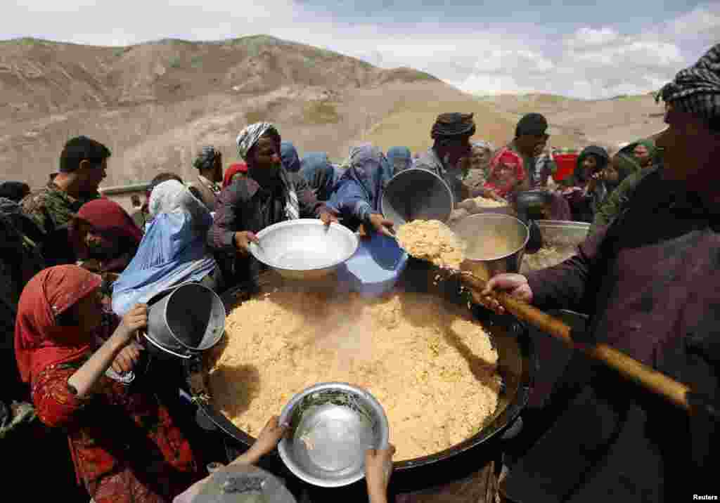 Para penyintas Afghanistan di distrik Argo, provinsi Badakhshan yang menjadi korban bencana tanah longsor, mendapatkan pembagian makan siang.
