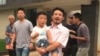 中国劳工权益活跃人士华海峰在江西赣州获得释放后抱着儿子离开（2017年6月28日）