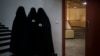 FILE - Women stand outside an auditorium at Kabul University's education center in Kabul, Afghanistan, Sept. 11, 2021. 