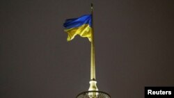 FILE PHOTO: A Ukrainian national flag flies over the parliament building in Kyiv