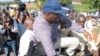 Uganda opposition leader Kizza Besigye being loaded into a police truck