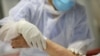 Una enfermera atiende a un paciente de edad avanzada contagiado con COVID-19 en Madrid, España.