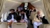 FILE - Afghanistans Foreign Minister Amir Khan Muttaqi, left, Taliban spokesman for the Ministry of Foreign affairs, Abdul Qahar Balkhi, center, and delegates sit on a plane before departing to Oslo, at the Kabul airport in Kabul. (Photo by Afghan Taliban / AFP)