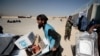 FILE - An UNHCR worker moved aid supplies at a distribution center on the outskirts of Kabul, Oct. 28, 2021. UNHCR said two journalists working for the relief agency and their local colleagues were detained by the Taliban, Feb. 11, 2022.