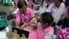 A woman cries while holding up a portrait of Thailand's King Bhumibol Adulyadej while his body is being moved from the Bangkok hospital where he died to the Grand Palace, in Bangkok, Thailand, Oct. 14, 2016. 