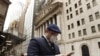 Un hombre usa una máscara protectora mientras camina por Wall Street en Nueva York.