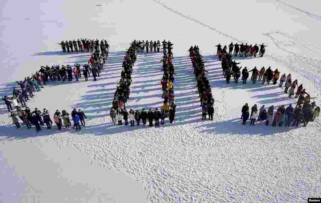 Students form &quot;2015&quot; standing on snow to welcome the upcoming New Year at Shenyang Agriculture University in Shenyang, Liaoning province, China.
