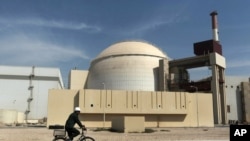 FILE - A worker rides in front of the reactor building of the Bushehr nuclear power plant, just outside Bushehr, Oct. 26, 2010. 