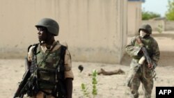FILE - Nigerian soldiers are seen on patrol near a Boko Haram camp in the north of Borno state.