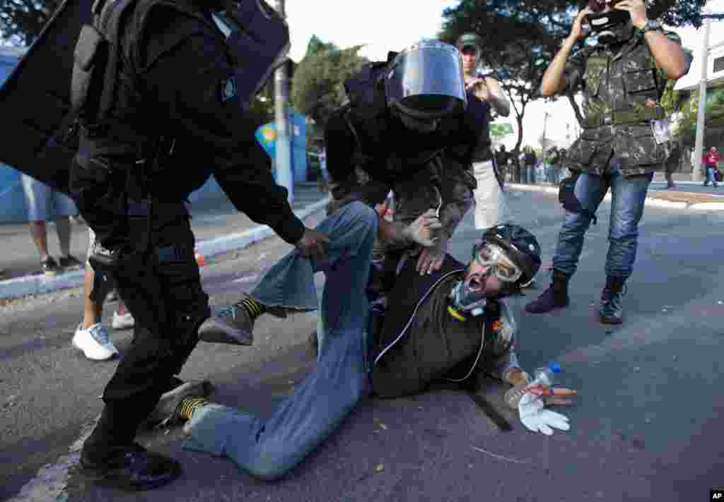 Riot police detain a man during a demonstration while Brazilian anti-government protesters rally, in part angered by the billions spent for World Cup preparations, Belo Horizonte, Brazil, June 26, 2013.&nbsp;