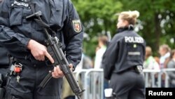 FILE - Police patrol near the Brandenburg Gate in Berlin, Germany, May 24, 2017.