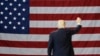 FILE - President Donald Trump waves in front of an American flag as he leaves after speaking during a rally at the Kentucky Exposition Center, March 20, 2017, in Louisville, Kentucky.