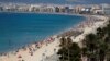 La gente toma el sol y nada en la playa de El Arenal en Palma de Mallorca, España, el 15 de agosto, 2020.
